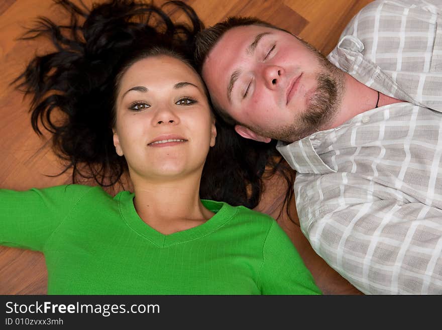 Happy couple lying on floor