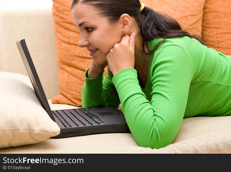 Attractive brunette woman on sofa with laptop. Attractive brunette woman on sofa with laptop