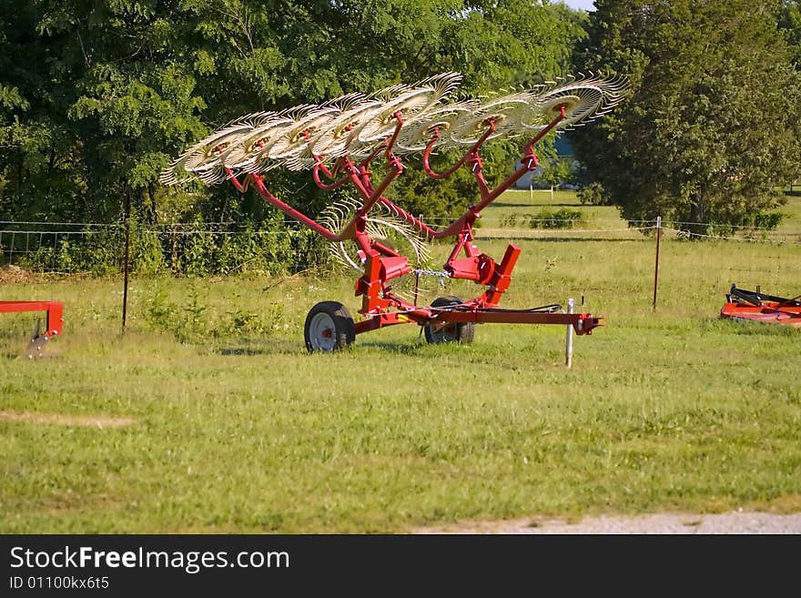 A small hay rake for sale on an impliment lot