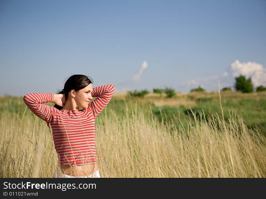 Attractive brunette woman relaxing on meadow. Attractive brunette woman relaxing on meadow