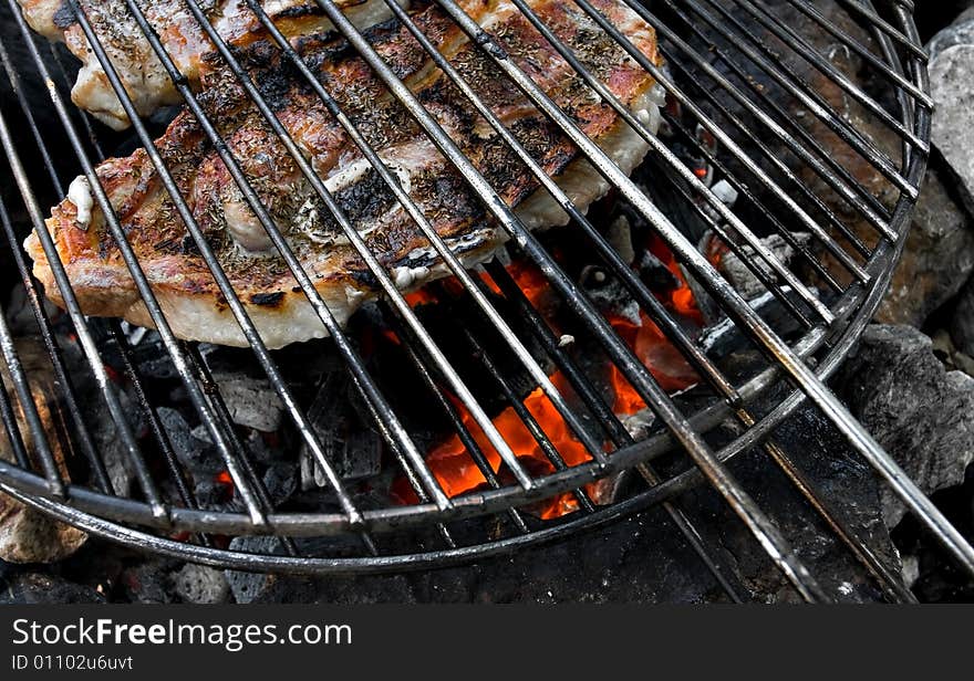 Meat on grill above campfire