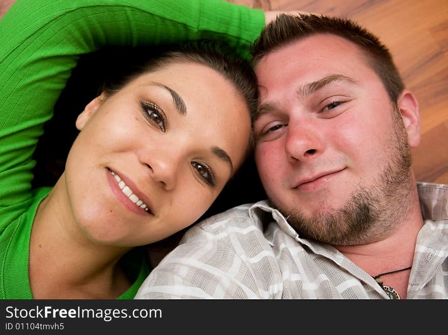 Happy couple lying on floor