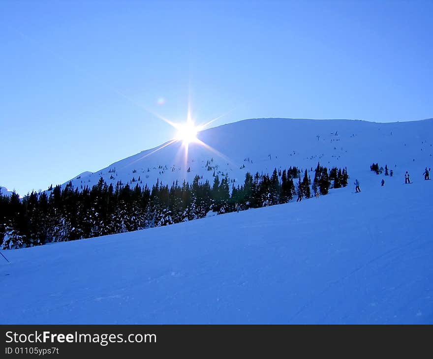 Sun behind of snowy hill. Sun behind of snowy hill.