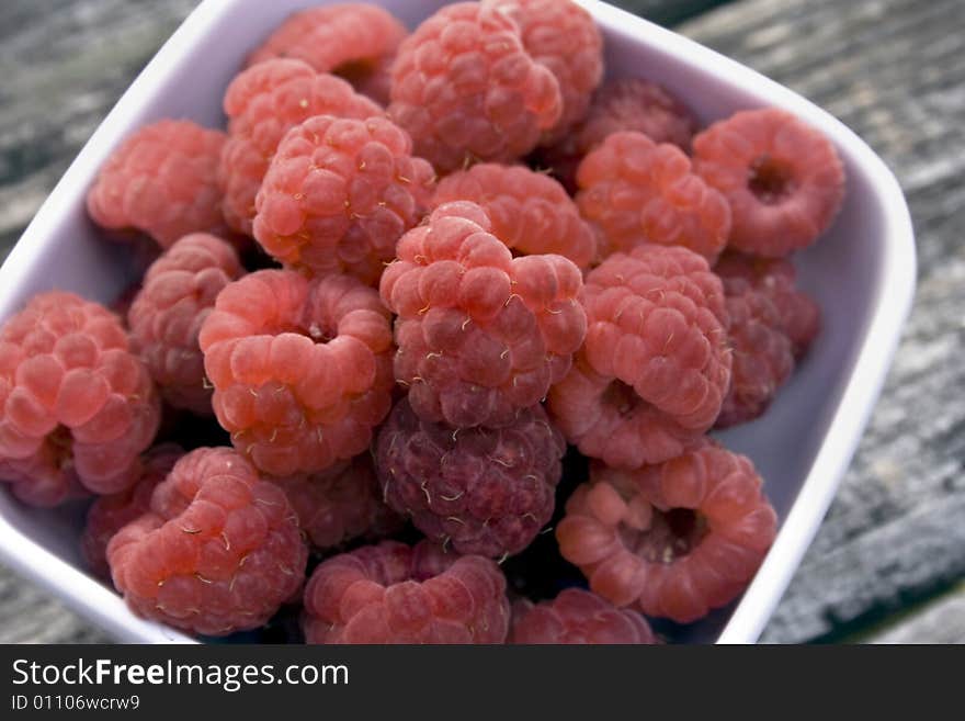 Red raspberries in a white bowl