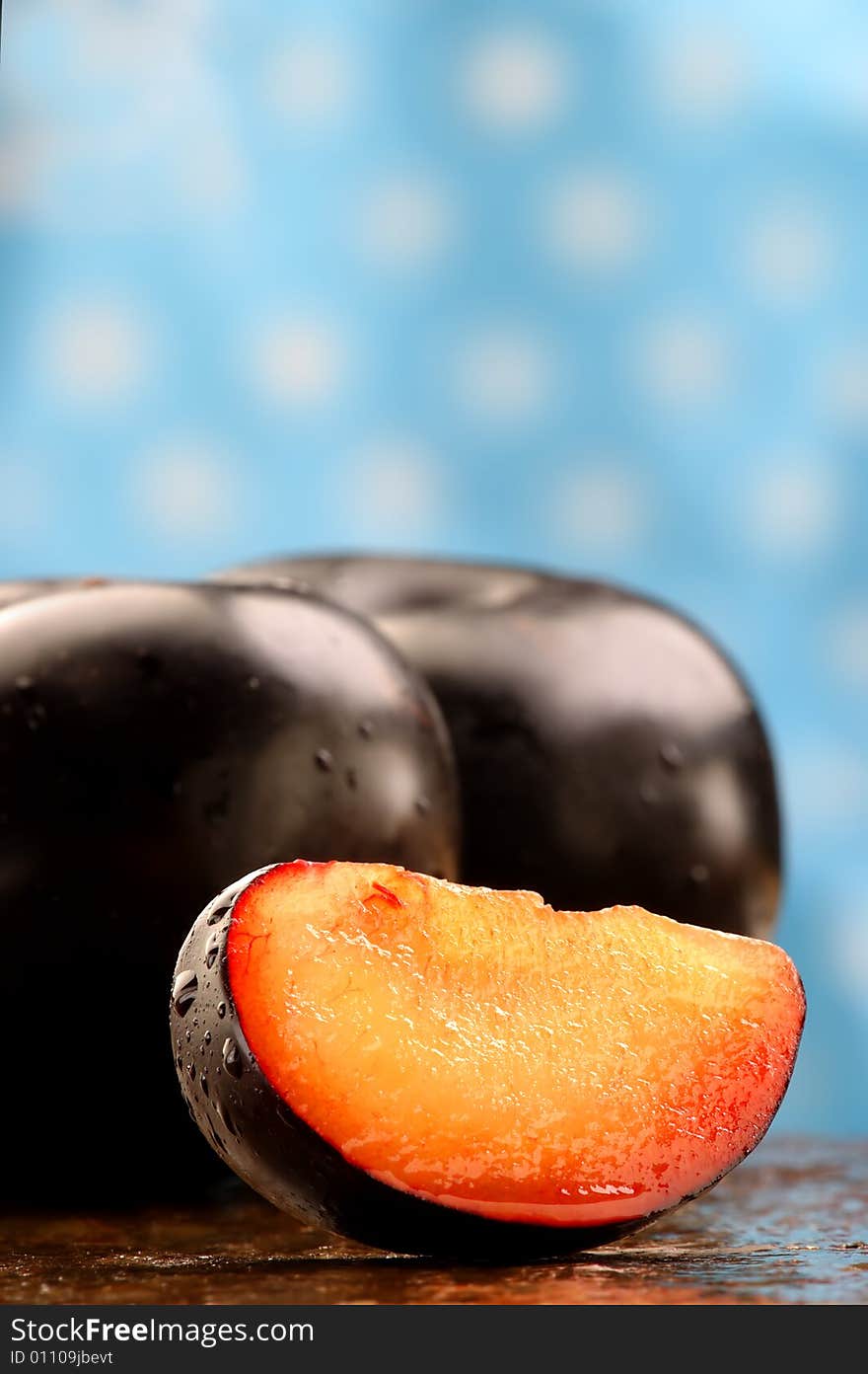 Fresh black plum slice on a stone counter. Fresh black plum slice on a stone counter.