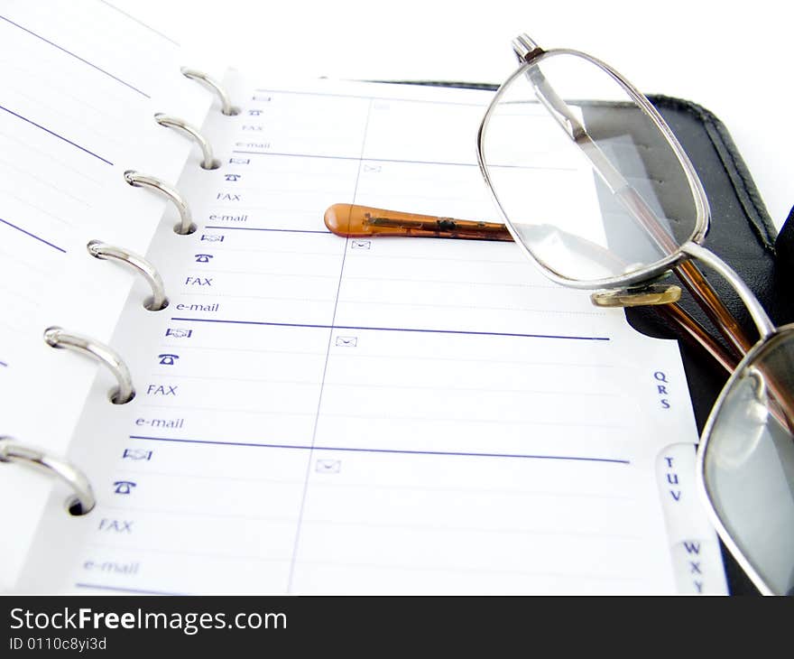 The opened notebook and glasses on a white background