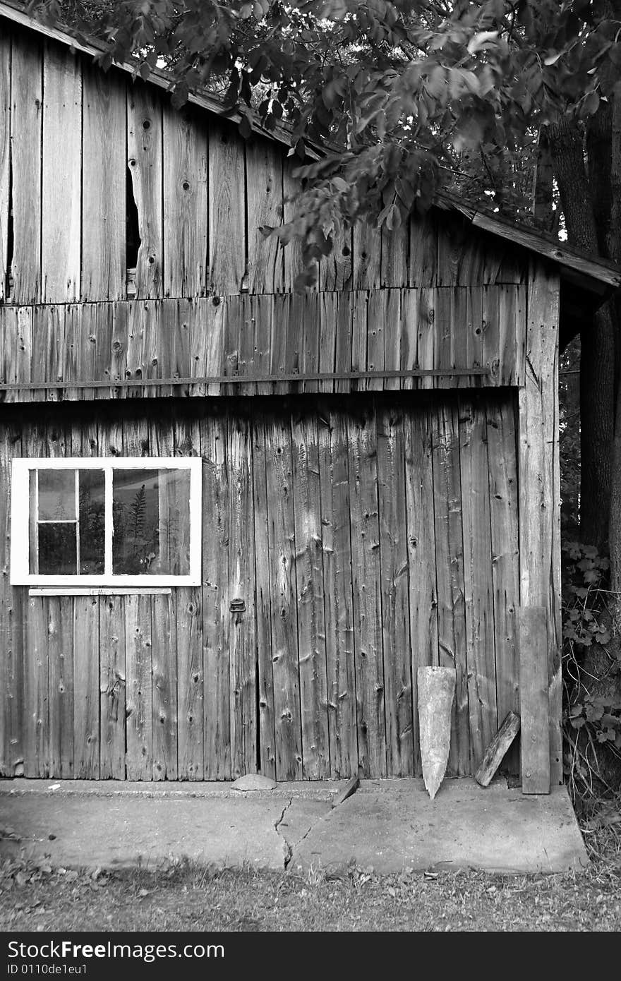 A side of an old, weathered barn in black and white.