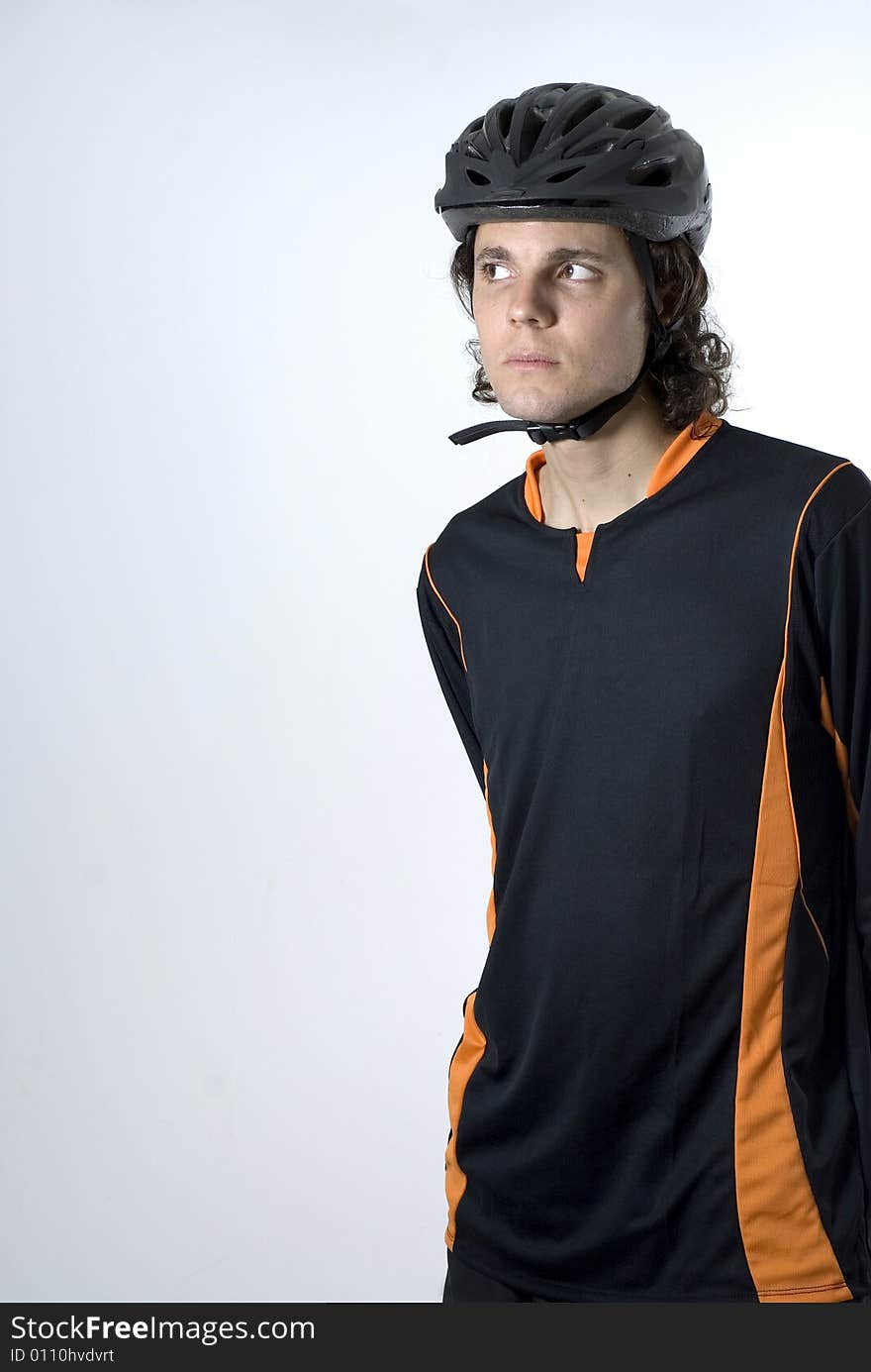 A man in a sports uniform is posing in a studio. He is looking away from the camera. Vertically framed shot. A man in a sports uniform is posing in a studio. He is looking away from the camera. Vertically framed shot.