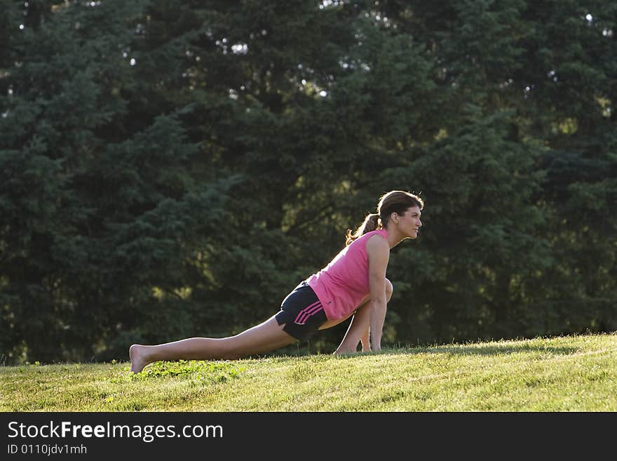 Woman Stretching On A Grassy Lawn - Horizontal