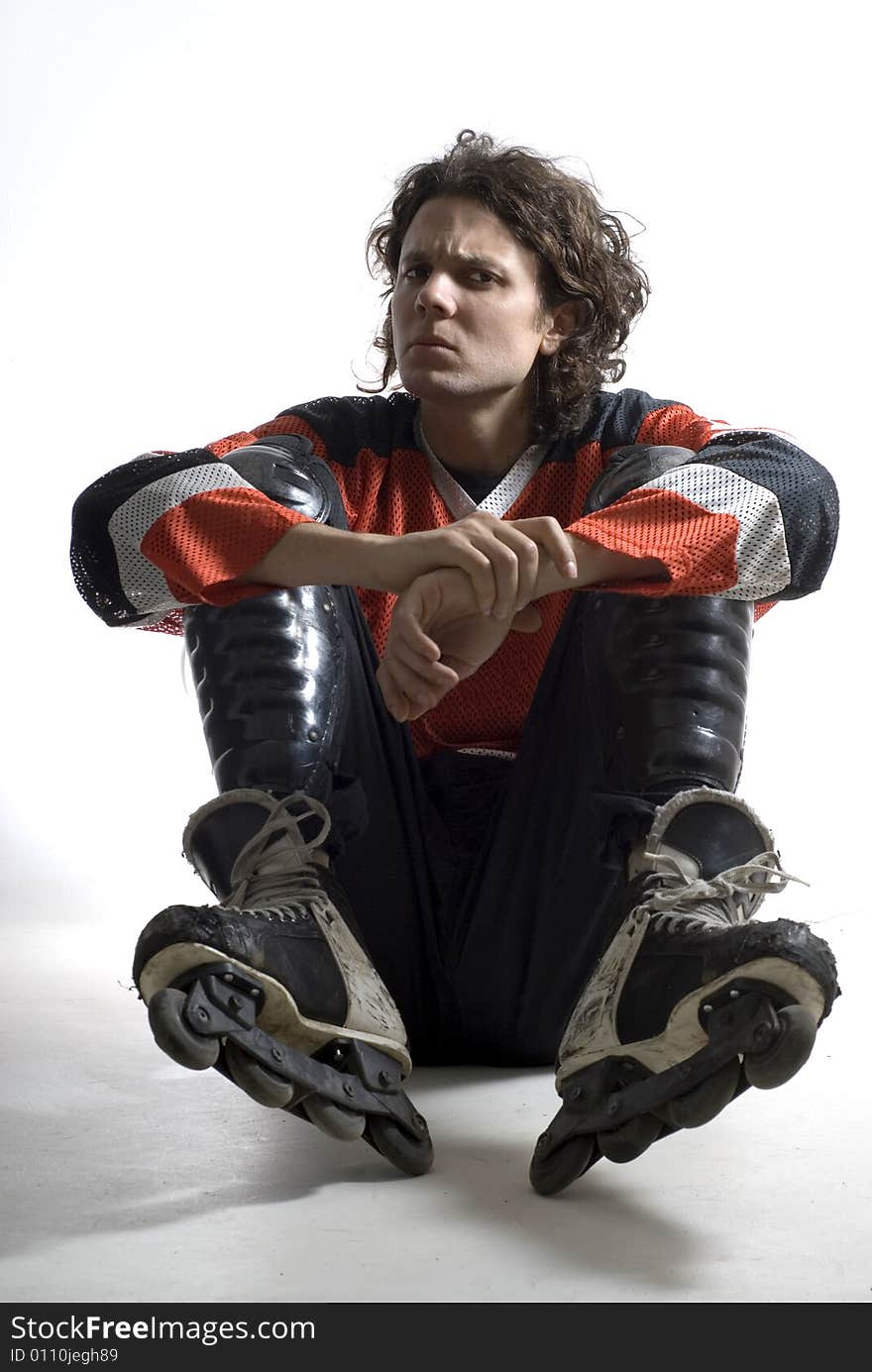 Rugby player sitting with his elbows on his knees looking angry. Vertically framed photograph. Rugby player sitting with his elbows on his knees looking angry. Vertically framed photograph