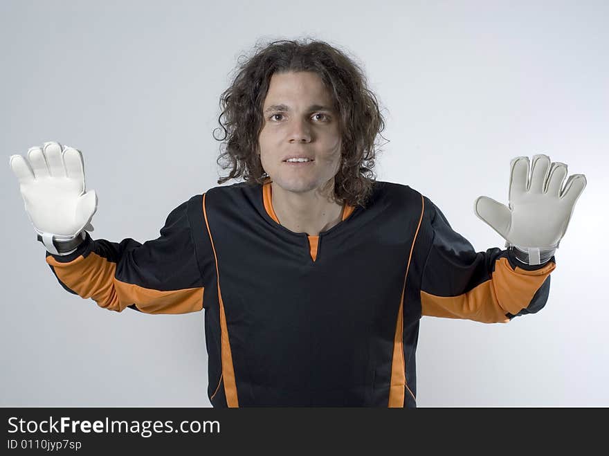 An athlete posing in a goalie stance.  His hands are gloved and he has his arms stretched out defensively. Horizontally framed shot. An athlete posing in a goalie stance.  His hands are gloved and he has his arms stretched out defensively. Horizontally framed shot.