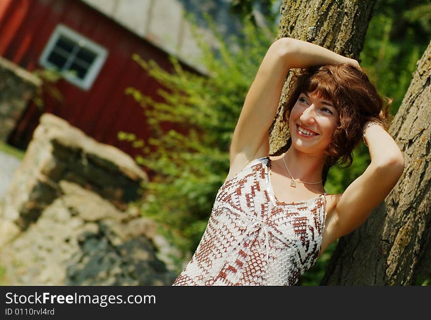 Pretty girl leaning against a tree. Pretty girl leaning against a tree.