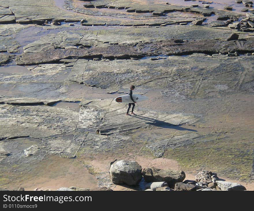 A disappointed surfer with no surf to catch a wave