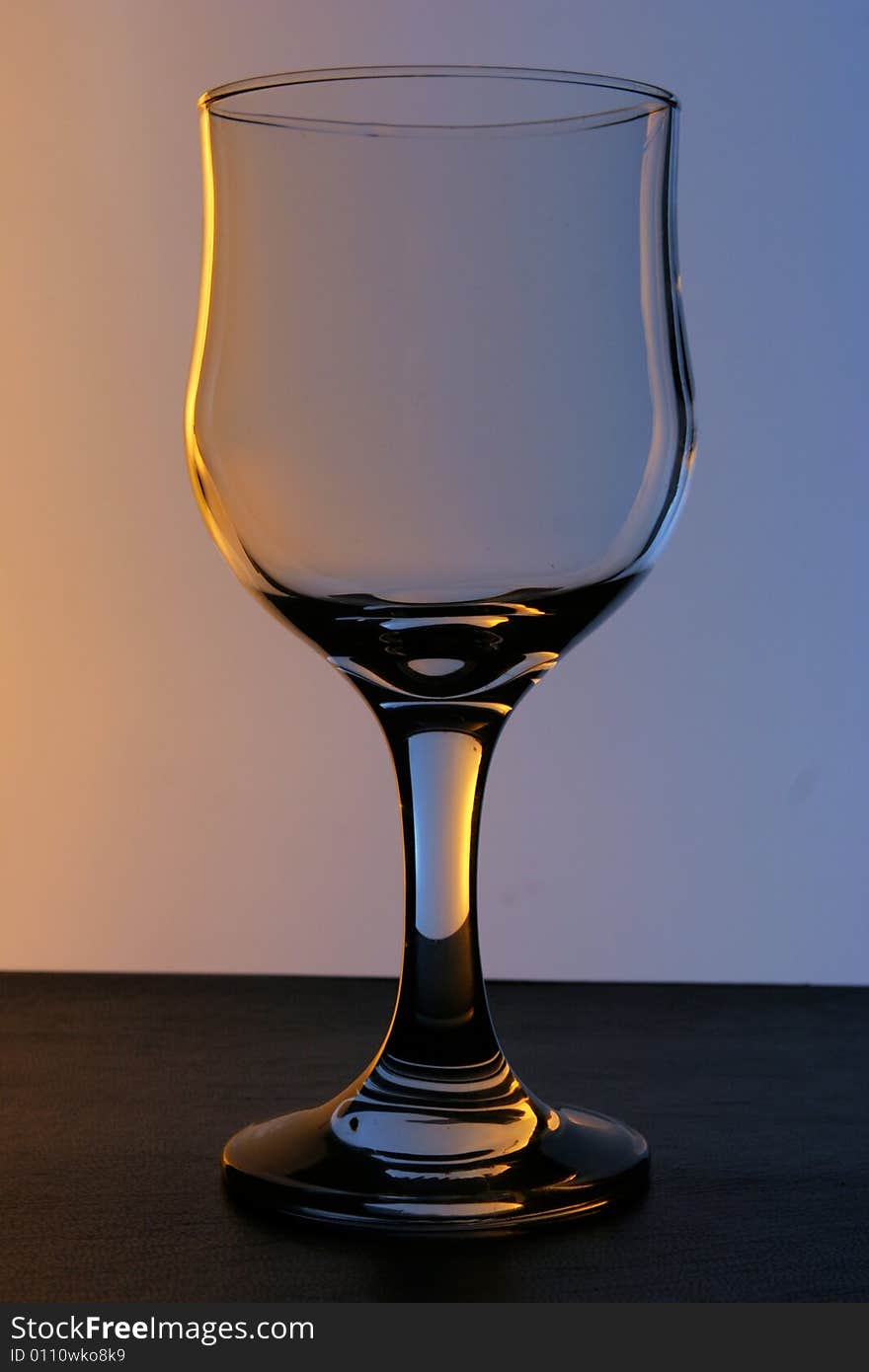 Empty wineglass in the studio; coloured lights