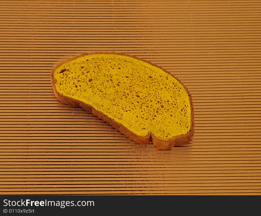 Yellow slice of bread on golden corrugated  board. Yellow slice of bread on golden corrugated  board