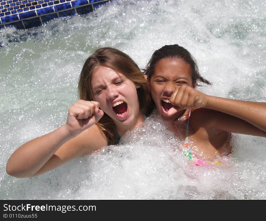 A picture of two tween girls in a jacuzzi prentending to be lead singers of a rock band. A picture of two tween girls in a jacuzzi prentending to be lead singers of a rock band.