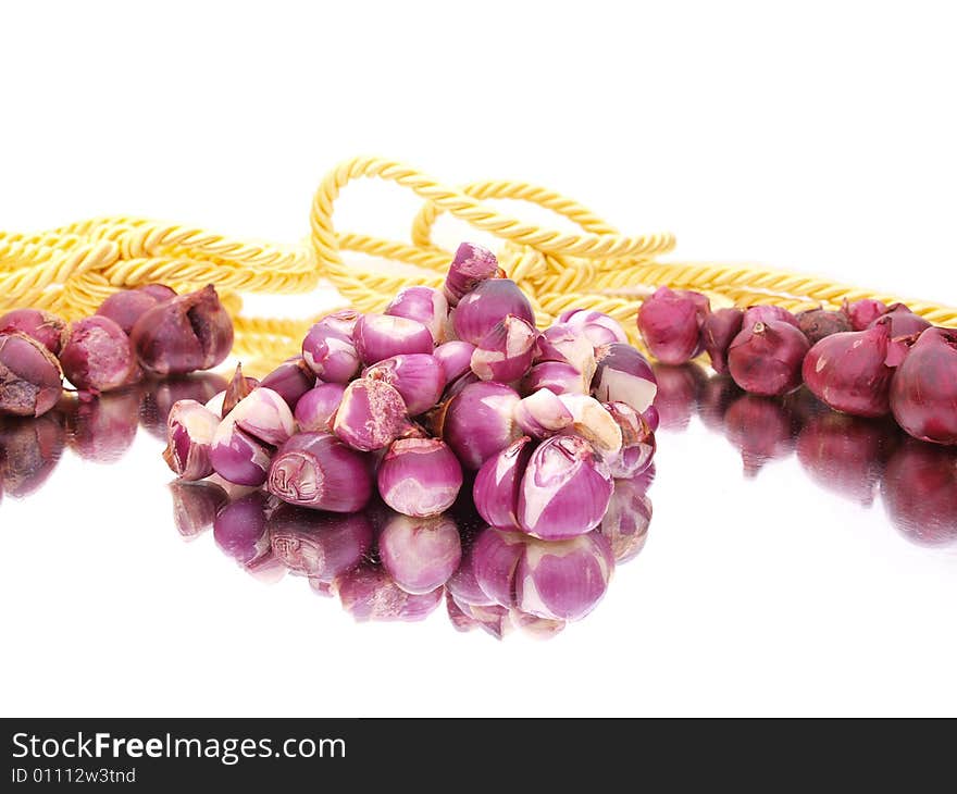 Peeled red onions composition with gold rope. Peeled red onions composition with gold rope