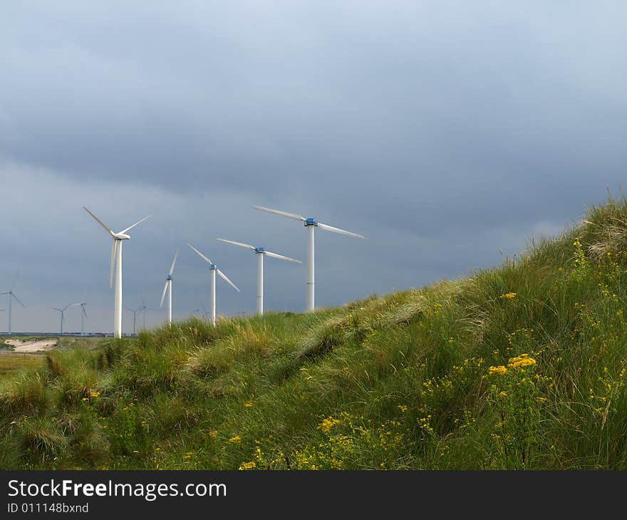 Wind turbines along the coast harvesting energy on a stormy day. Wind turbines along the coast harvesting energy on a stormy day