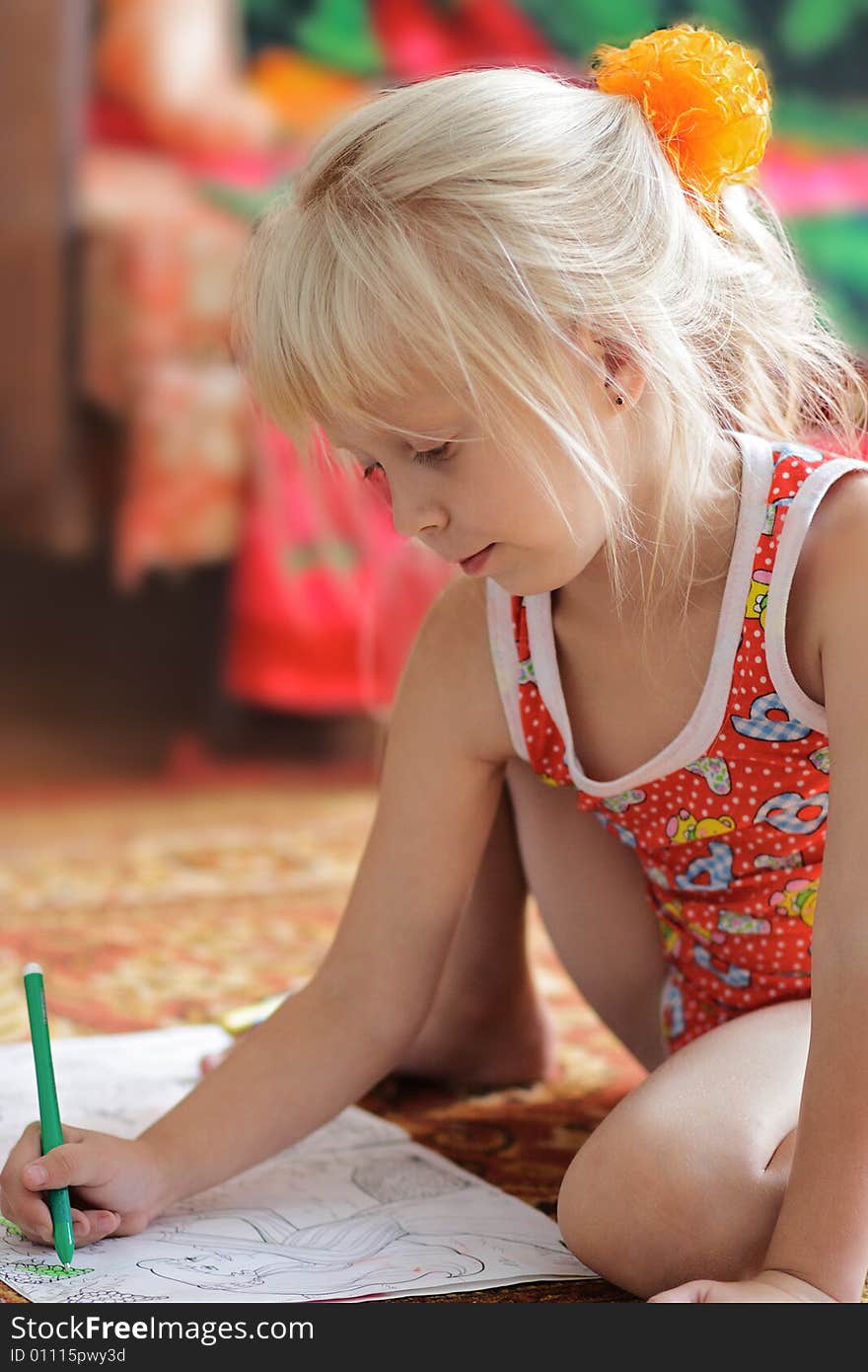 The girl with enthusiasm draws sitting on a floor. The girl with enthusiasm draws sitting on a floor