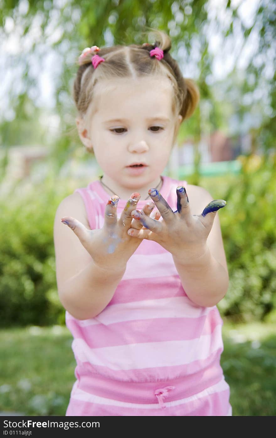 Little girl with hands in paints