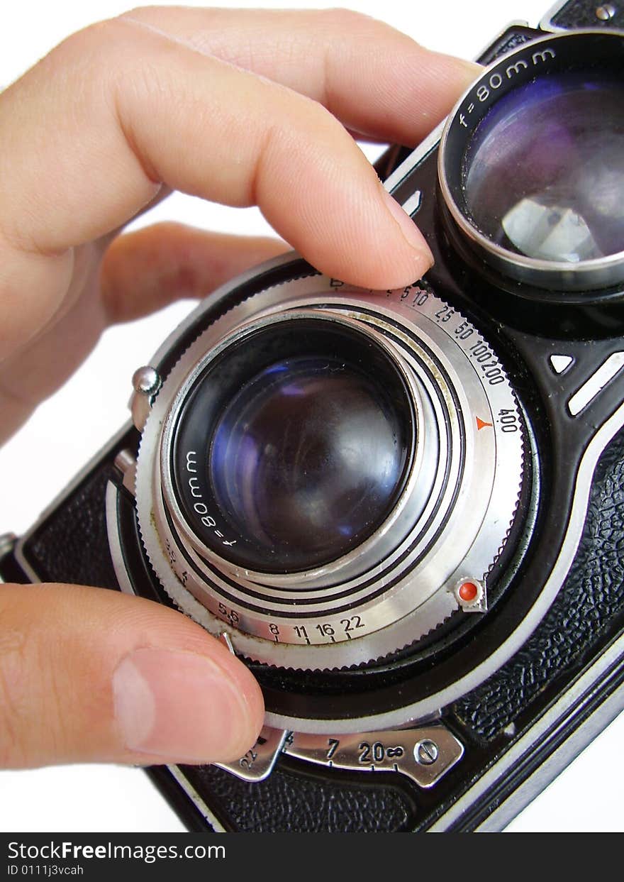 Vintage camera focusing hand on white background.