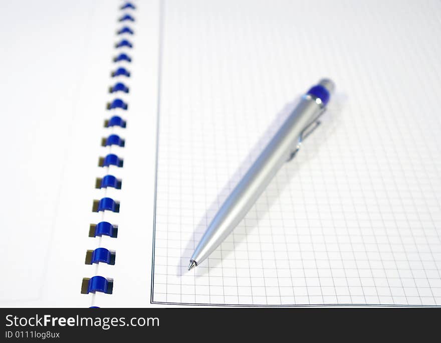 One silver pen and spiral notebook closeup