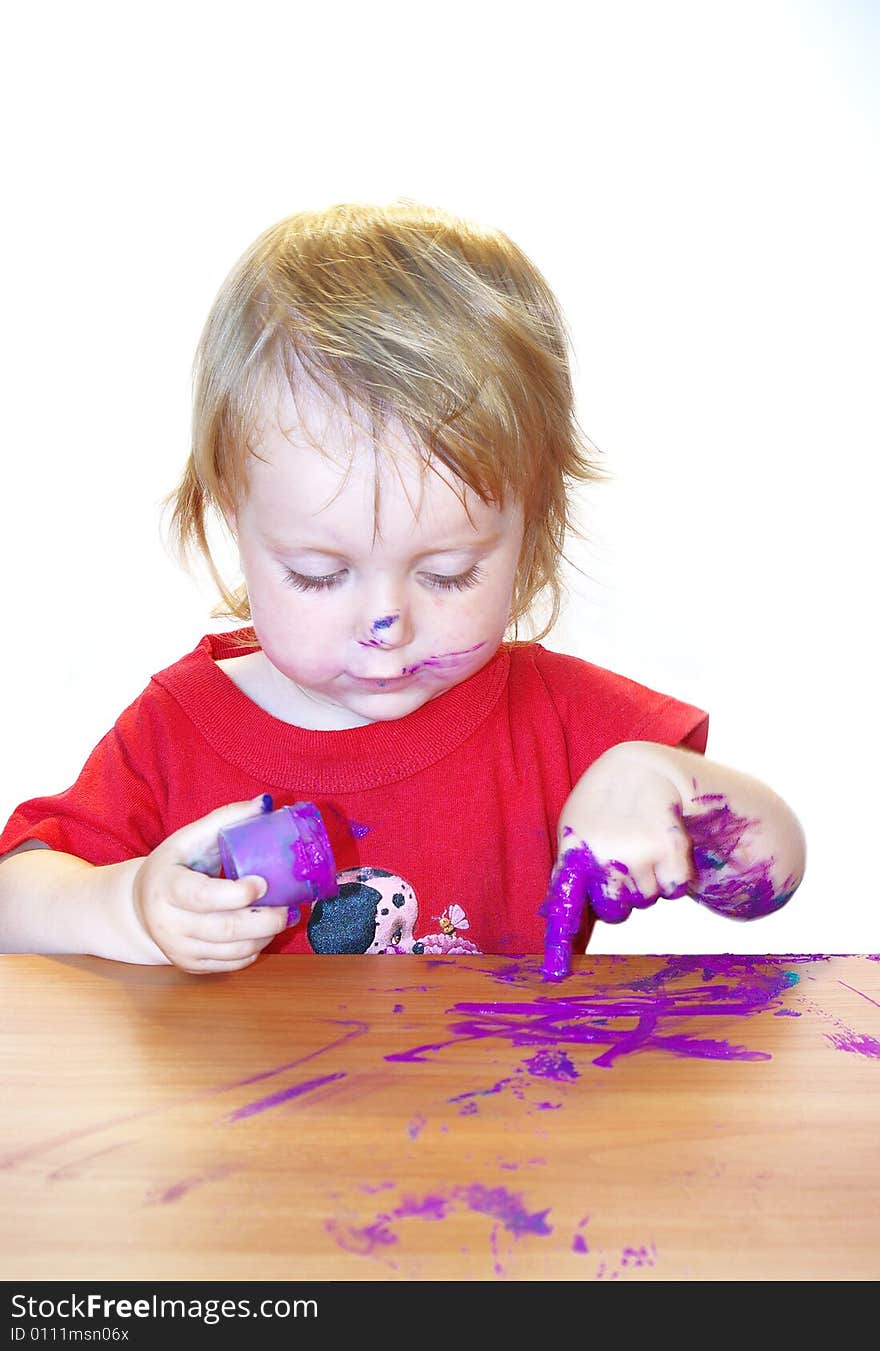 Little girl draws on a table isolated