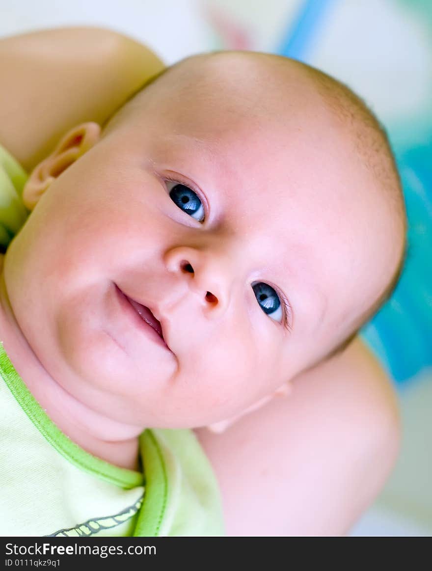 Seven week baby lying on mother's laps. Baby is smiling straight at camera. Seven week baby lying on mother's laps. Baby is smiling straight at camera.