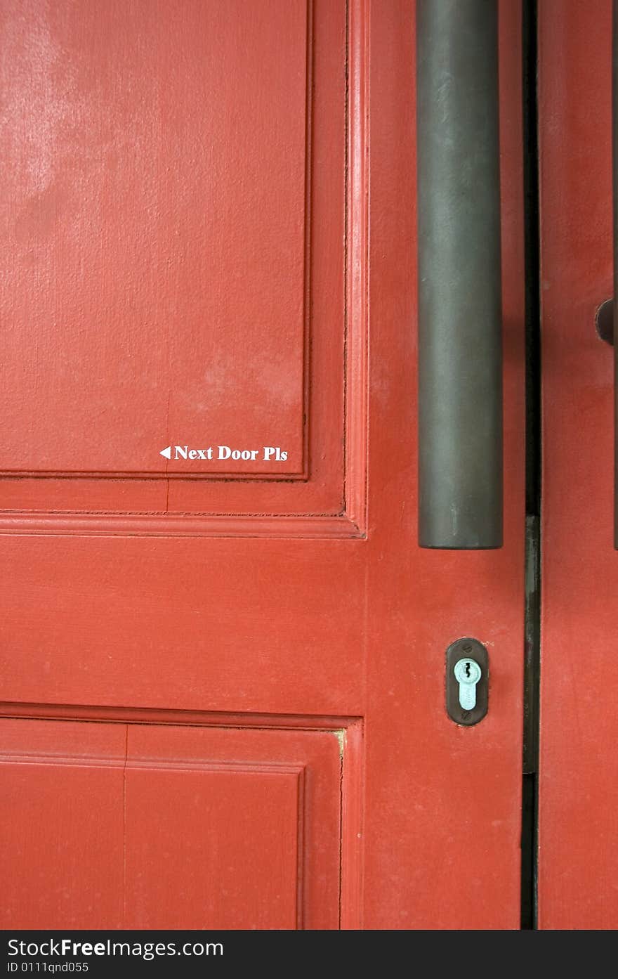 A door painted with words that says Next Door Please.