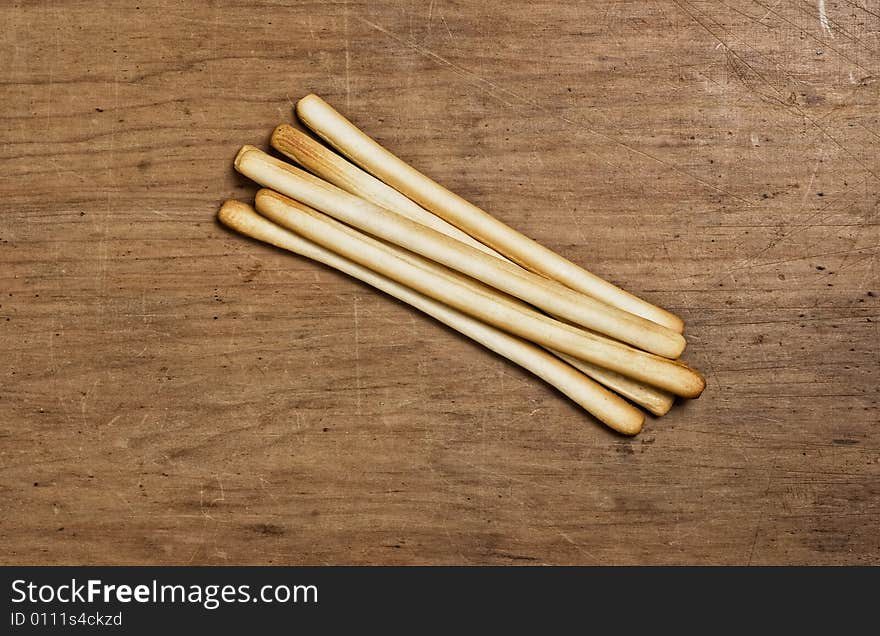 Bunch of Bread sticks on a wooden table.