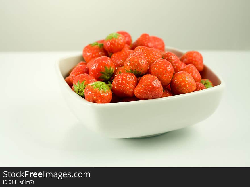 Strawberry in white bowl on white background