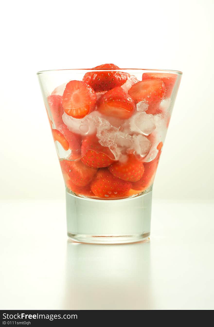 Strawberry in glass with ice on white background