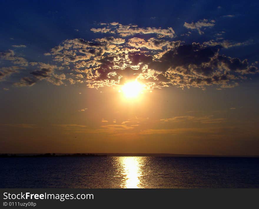 Sundown over the river. Beautiful clouds and path on water. Sundown over the river. Beautiful clouds and path on water.