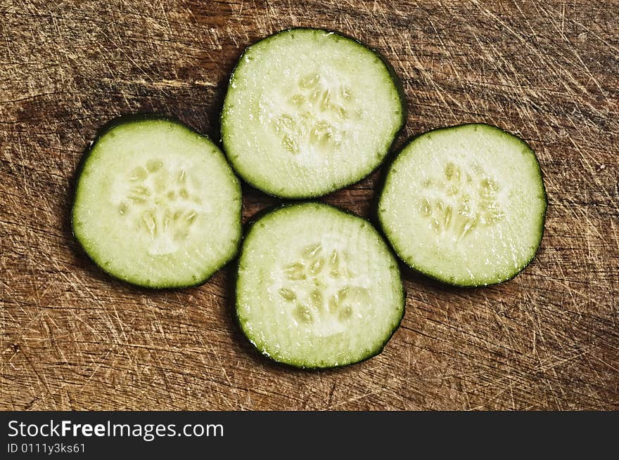 Slices of cucumber on a wooden background.