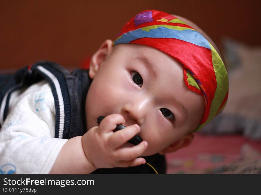 Little baby under red kerchief smiling.