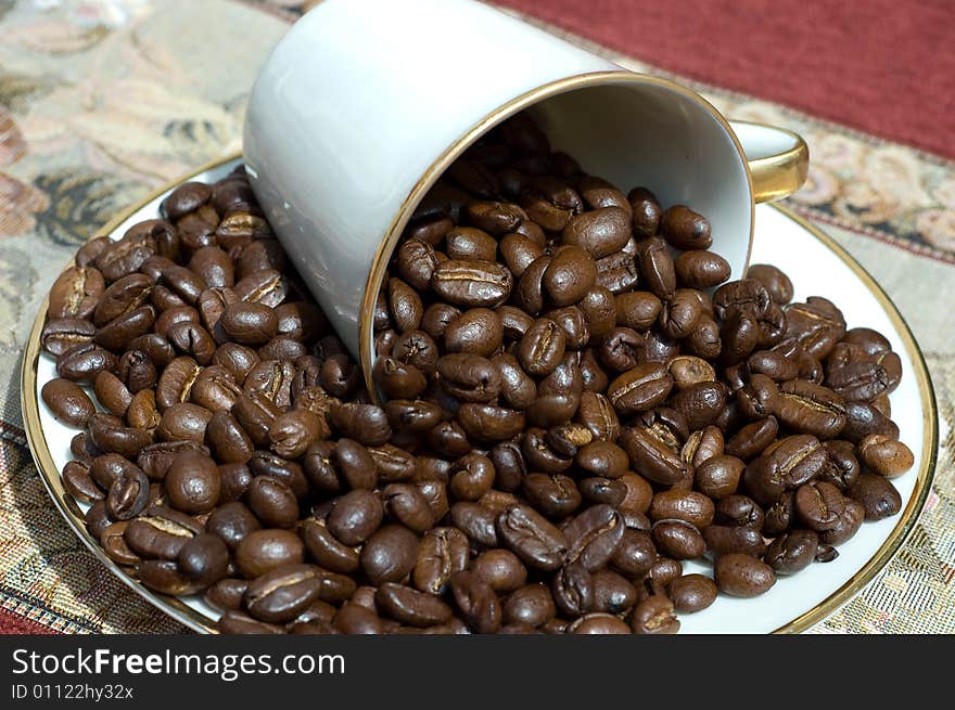 Coffee beans in fallen white retro cup. Coffee beans in fallen white retro cup