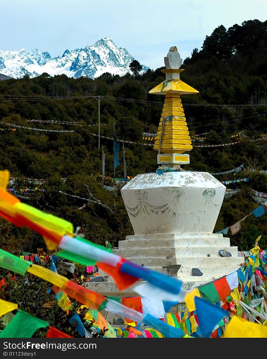 Tibetan tower and prayer flag with snow mountain in background,Yunnan,china