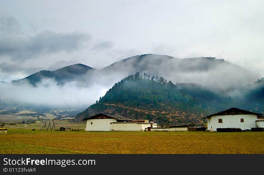 Tibetan village with mountian and clouds in background,Yunnan,china