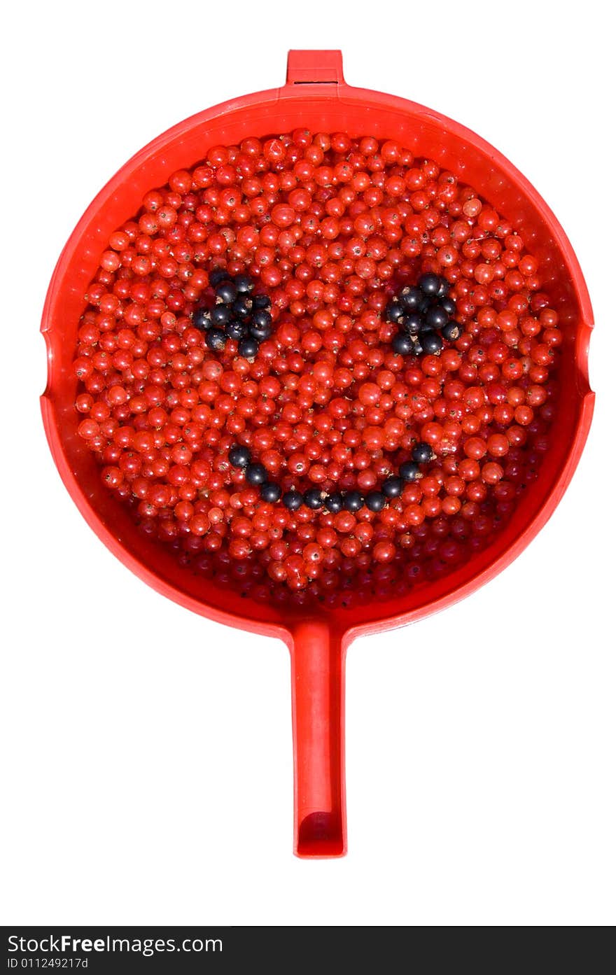 Red and black currants, painting a smile in a red scoop. Red and black currants, painting a smile in a red scoop