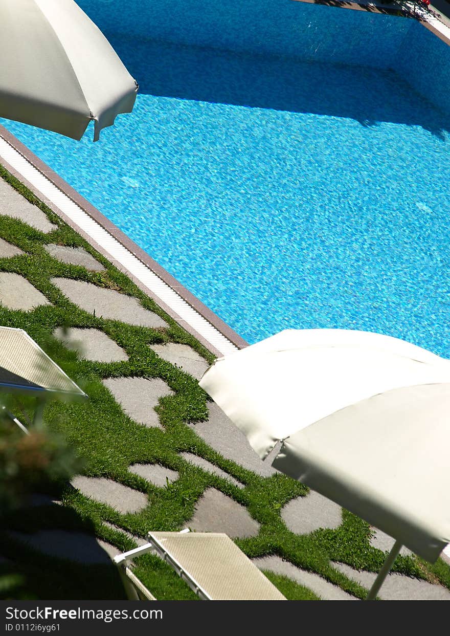 An original shot of a pool and beach umbrellas that recall the summer