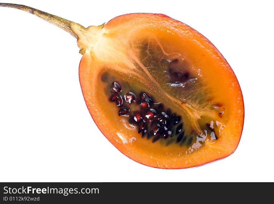 Cut half of a fresh Tamarillo fruit showing its deep red seeds and tangy sweet flesh. Cut half of a fresh Tamarillo fruit showing its deep red seeds and tangy sweet flesh