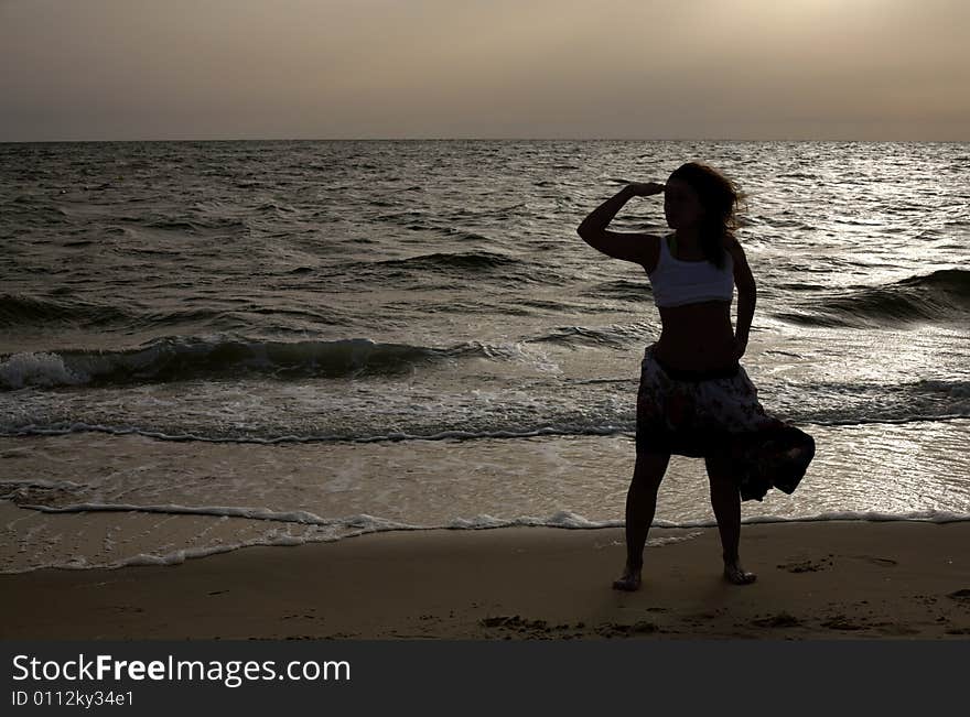 Silhouette of girl at dawn at the sea