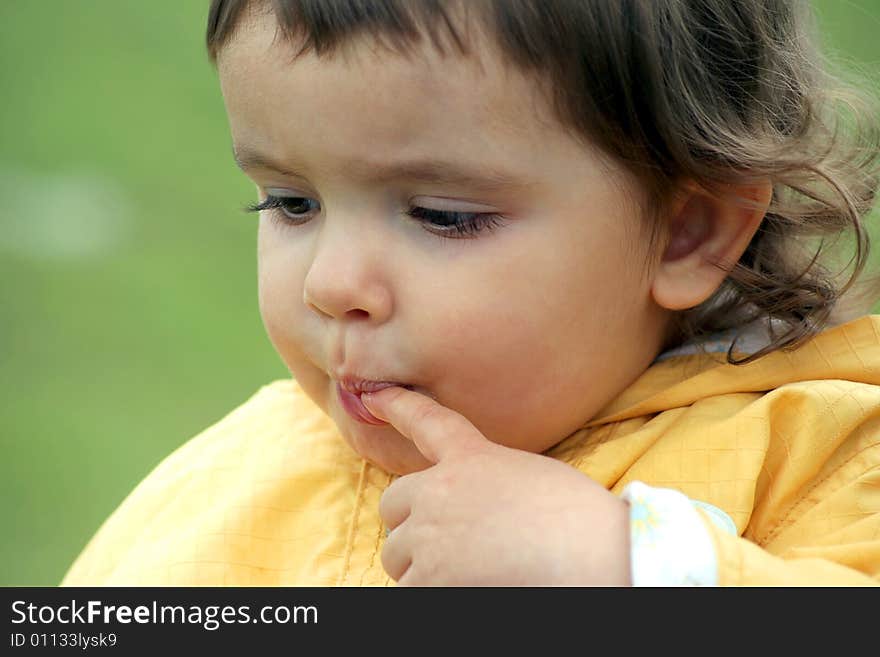 Little girl in deep thoughts put her finger in the mouth. Little girl in deep thoughts put her finger in the mouth