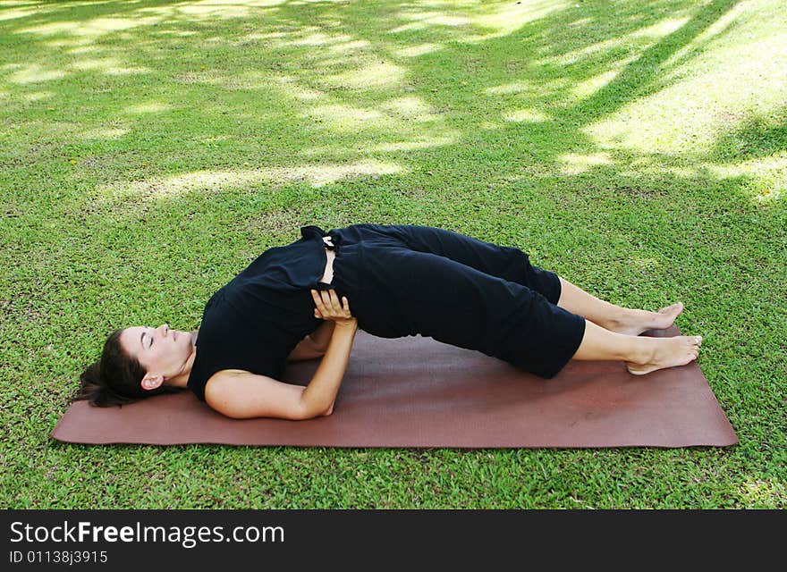 Young woman practicing yoga in the park.