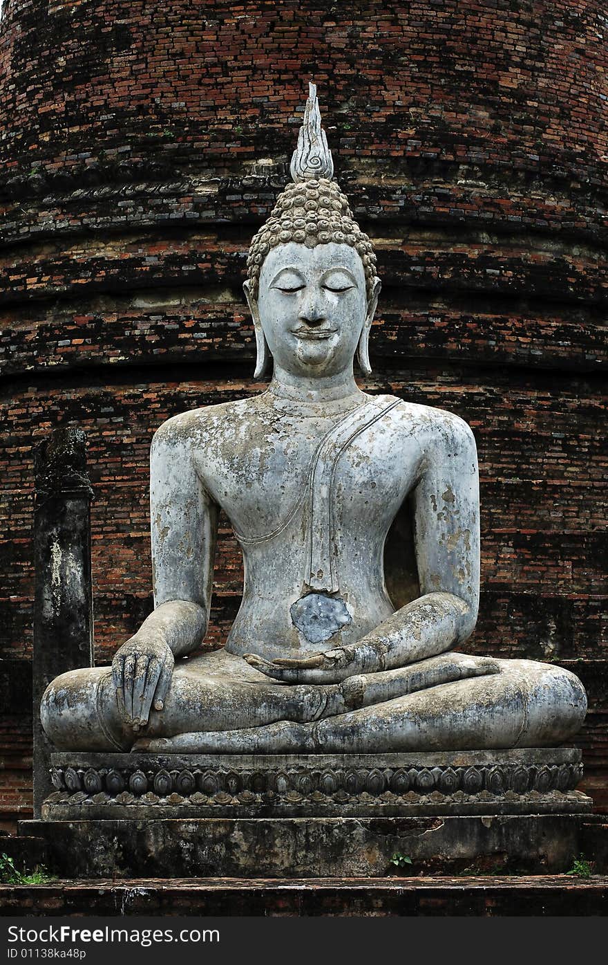 Thailand, Sukhothai or Sukothai was the capital of the Thai Empire founded in 1238. Detail of a seated Buddha statue at Phra Atchana or Ajana at wat Si Chum; a hand. Thailand, Sukhothai or Sukothai was the capital of the Thai Empire founded in 1238. Detail of a seated Buddha statue at Phra Atchana or Ajana at wat Si Chum; a hand