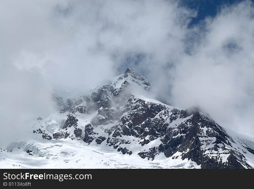 Snowy mountain in Yunan, China, under cloudy sky. Snowy mountain in Yunan, China, under cloudy sky