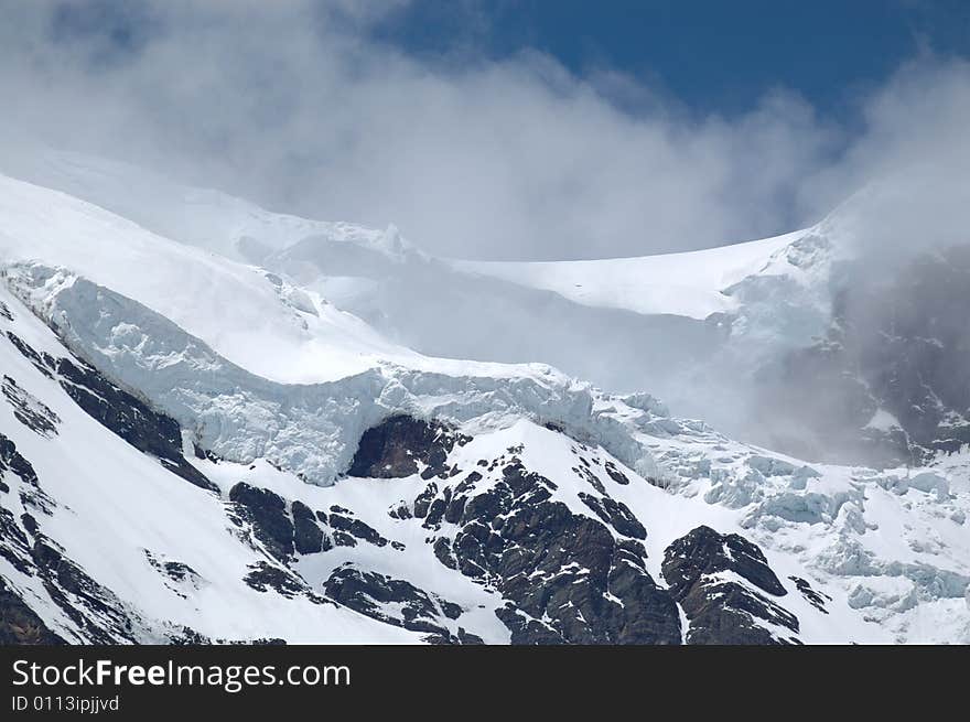 Snowy mountain in Yunan, China, under cloudy sky. Snowy mountain in Yunan, China, under cloudy sky