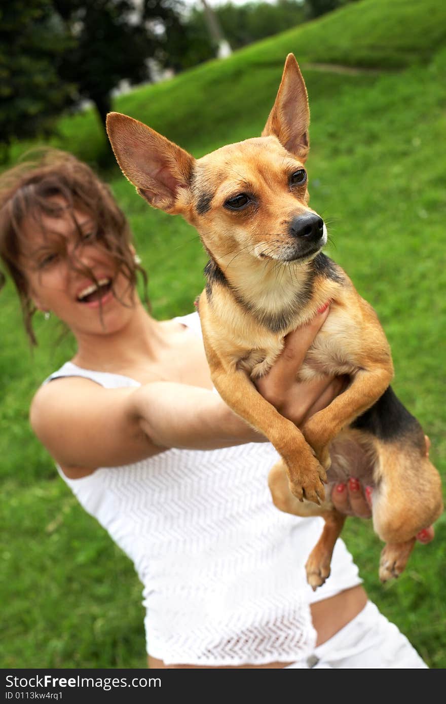 Girl and her doggy on green grass background; focus on dog. Girl and her doggy on green grass background; focus on dog