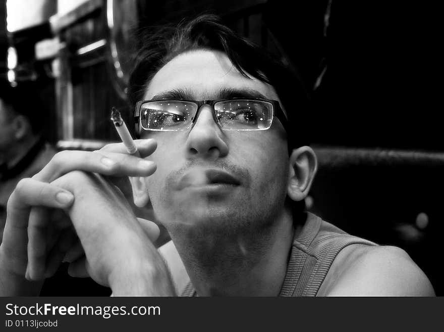 A young man with a cigarette in a cafe. A young man with a cigarette in a cafe