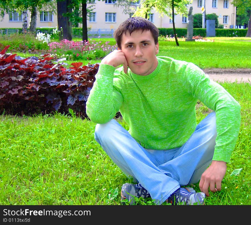 Photo of the young thoughtful person on a grass.